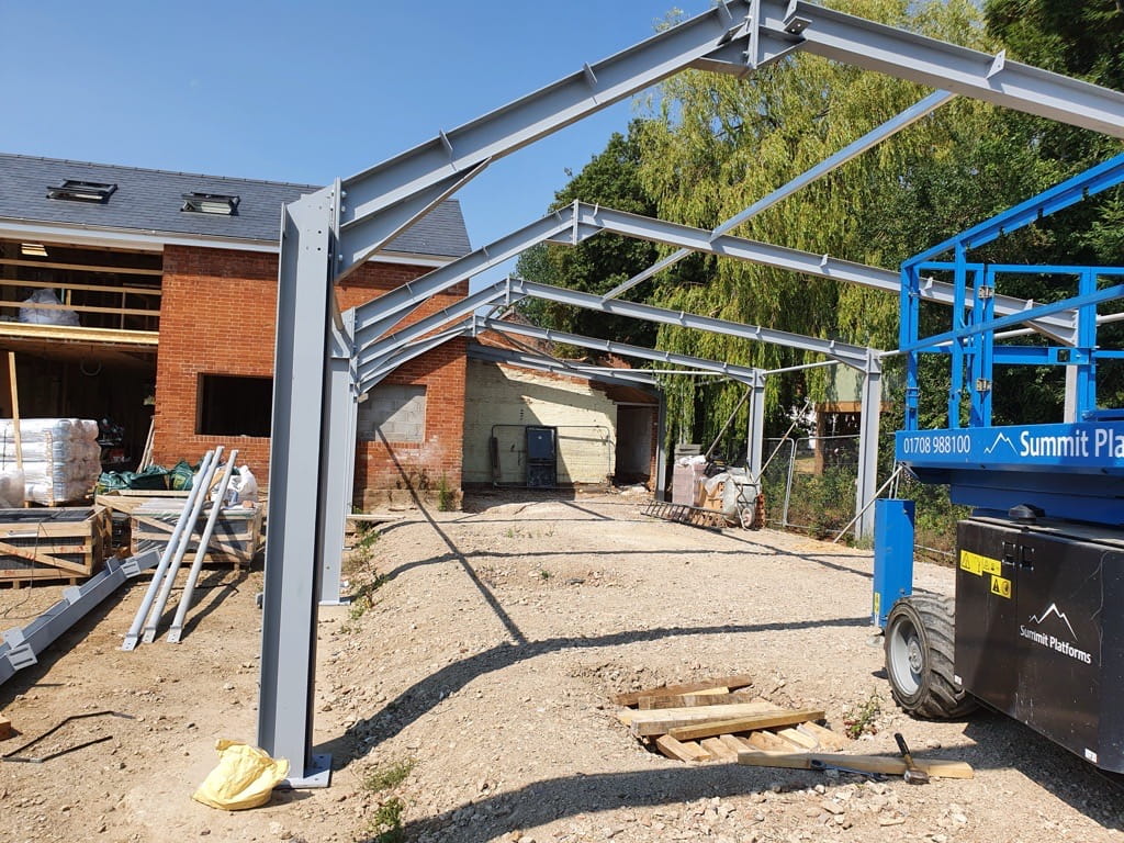 Structural steel beams and columns forming the frame for an extension on a traditional brick built building to create a commercial office